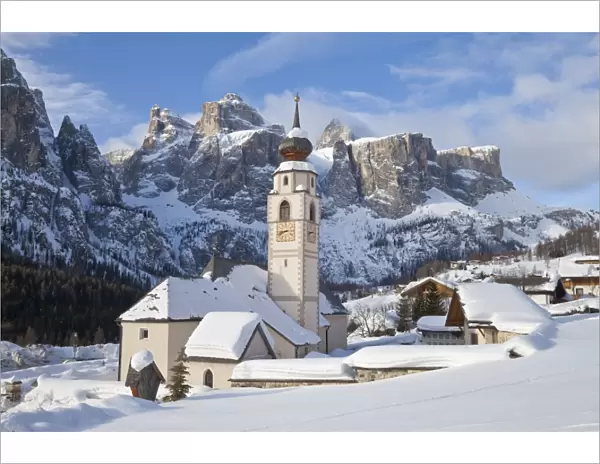 The church and village of Colfosco in Badia, 1645, and Sella Massif range of mountains under winter snow, Dolomites, South Tirol, Trentino-Alto Adige