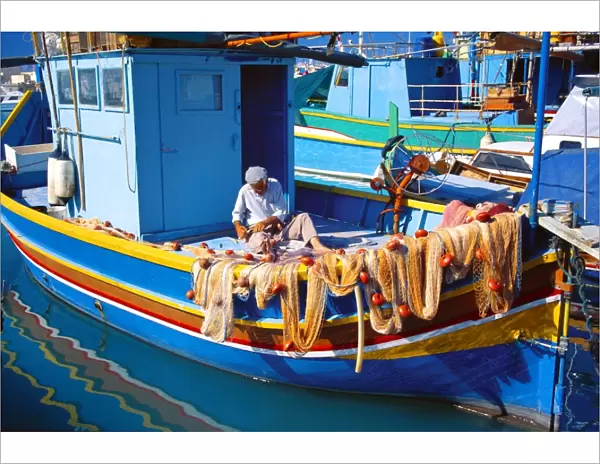 Fisherman knotting a fishing net, Marsaxlokk, Malta, Mediterranean, Europe