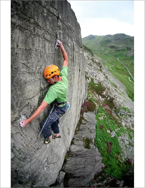A rock climber makes a first ascent of on the cliffs above the Llanberis Pass