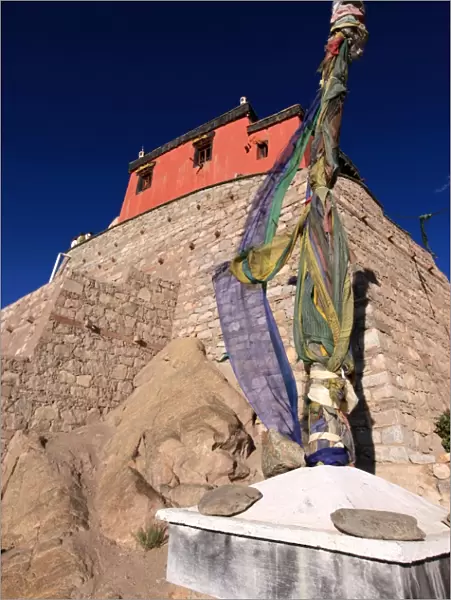 A stupa bound with prayer flags stands under the walls of Leh Palace, Leh