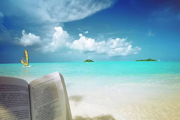 Reading book on the beach, windsurfing and islands in the distance, the Maldives