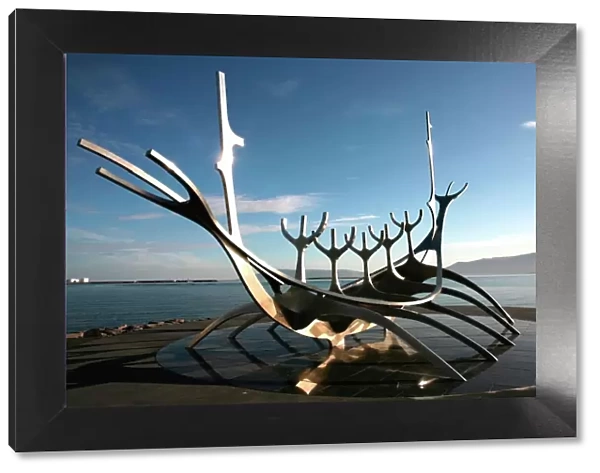 The midnight sun lights up the giant steel boat sculpture that stands on the waters edge at Reykjavik, Iceland