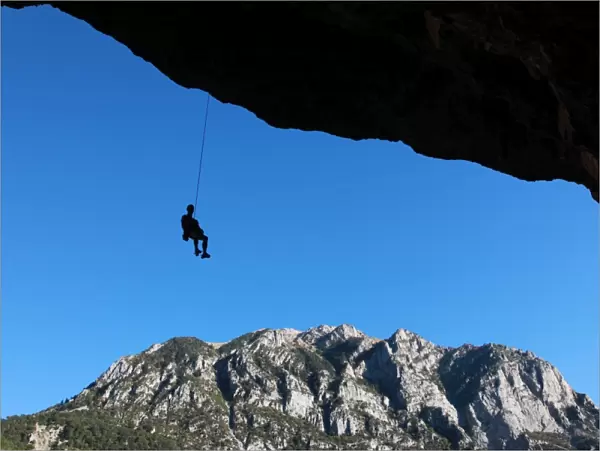 A climber lowers off a very overhanging cave climb on the cliffs above Bielsa