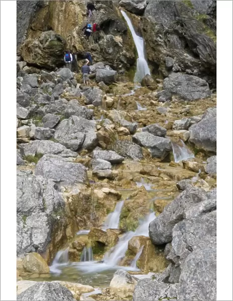 Climbing up the waterfalls at Goredale Scar at Malham Cove, Malhamdale