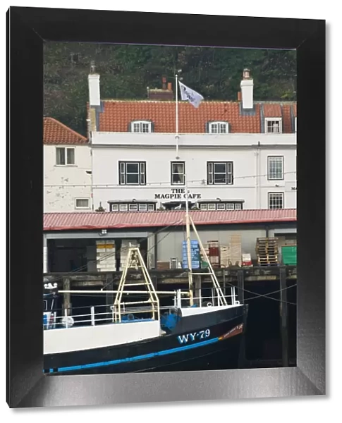 Fishing boats in Whitby harbour with the famous Magpie Cafe in the background