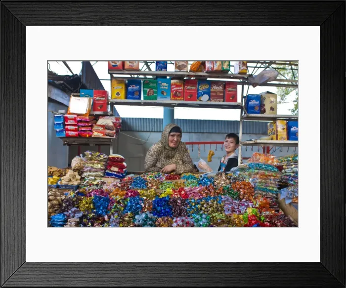 Framed Print : Woman and her son selling sweets on a market stand in the Bazaar of Osh Framed Print : Woman and her son selling sweets on a market stand in the Bazaar of Osh