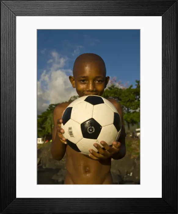 Framed Print : A dark skinned boy smiling and holding a football, Moroni, Grand Comore, Comores, Africa Framed Print : A dark skinned boy smiling and holding a football, Moroni, Grand Comore, Comores, Africa