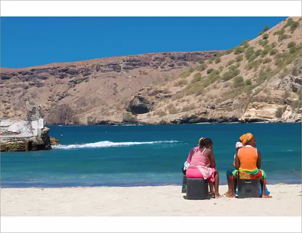 Two women sitting on the sandy beach talking, Tarrafal, Santiago, Cabo Verde, Africa