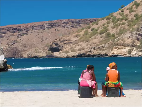 Two women sitting on the sandy beach talking, Tarrafal, Santiago, Cabo Verde, Africa