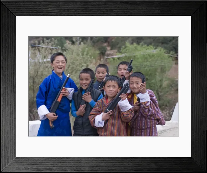 Framed Print : Young Bhutanese boys playing with their toy guns, Paro, Bhutan, Asia