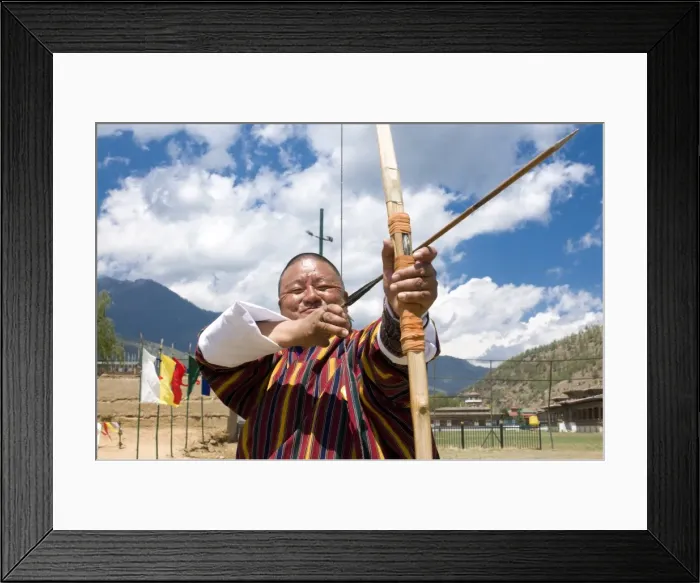 Framed Print : Traditionally dressed Bhutanese man practising the national sport of archery in the national stadium, Thimpu Framed Print : Traditionally dressed Bhutanese man practising the national sport of archery in the national stadium, Thimpu