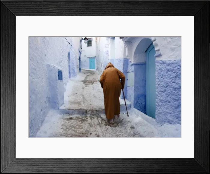 Framed Print : Old man walking in a typical street in Chefchaouen, Rif mountains region Framed Print : Old man walking in a typical street in Chefchaouen, Rif mountains region