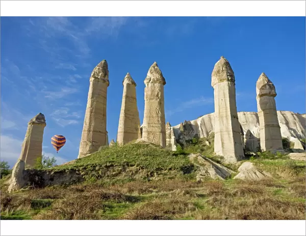Hot air balloon over the phallic pillars known as fairy chimneys in the valley known as Love Valley near Goreme in Cappadocia, Anatolia, Turkey, Asia