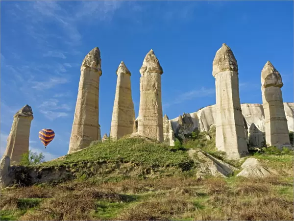 Hot air balloon over the phallic pillars known as fairy chimneys in the valley known as Love Valley near Goreme in Cappadocia, Anatolia, Turkey, Asia
