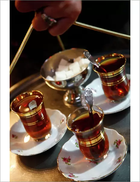 Hand holding a tray with Turkish tea, Istanbul, Turkey, Europe