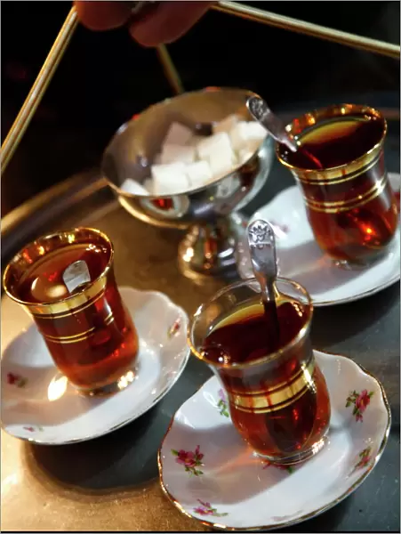 Hand holding a tray with Turkish tea, Istanbul, Turkey, Europe