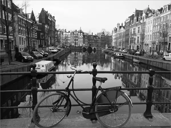Black and white imge of an old bicycle by the Singel canal, Amsterdam, Netherlands