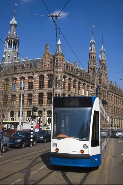 Modern tram with the Magna Plaza building behind, Amsterdam, Netherlands, Europe