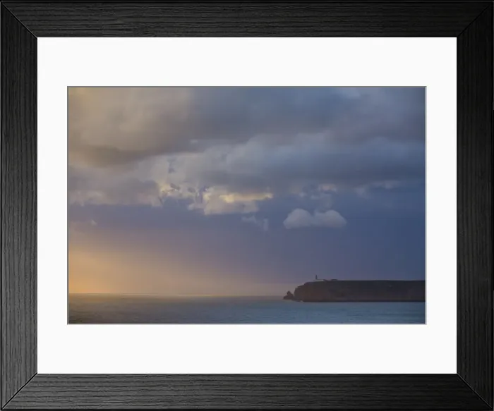 Framed Print : Stormy sunset over Atlantic ocean and cliffs at Cape St. Vincent with lighthouse in the distance Framed Print : Stormy sunset over Atlantic ocean and cliffs at Cape St. Vincent with lighthouse in the distance