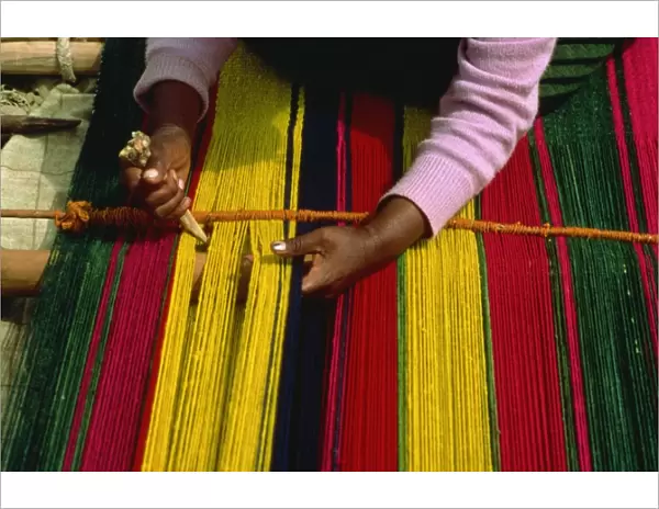 An Indian woman weaving a carpet in small village by Lake Titicaca, Bolivia