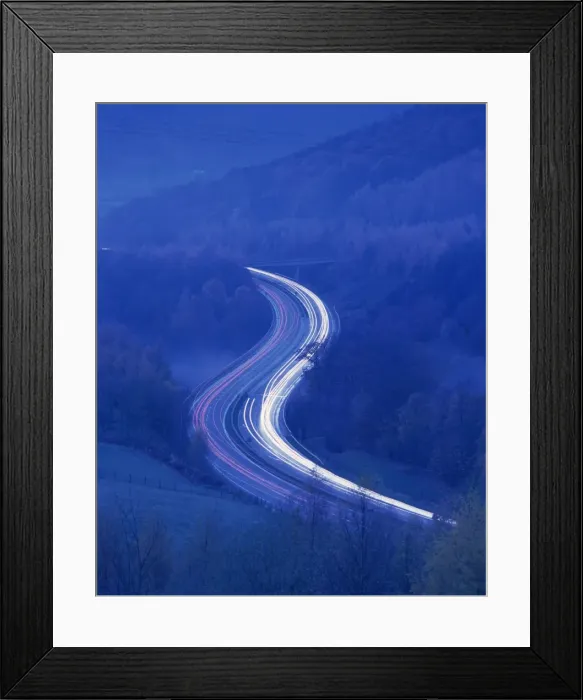 Framed Print : Light trails on rural road at twilight through woods in the Lake District Framed Print : Light trails on rural road at twilight through woods in the Lake District