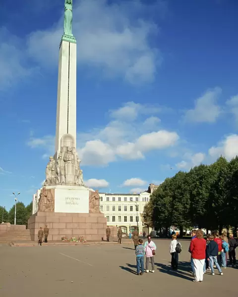 Latvians and guards in front of the Freedom Monument in the city of Riga
