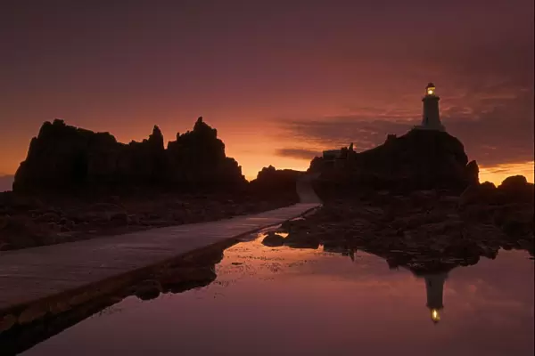 Dramatic sunset, low tide, Corbiere lighthouse, St. Ouens, Jersey, Channel Islands