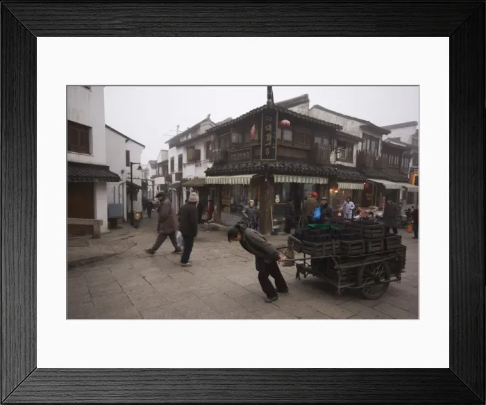 Framed Print : A woman pulling a cart of charcoal bricks on an old street in Shantang district of Suzhou Framed Print : A woman pulling a cart of charcoal bricks on an old street in Shantang district of Suzhou
