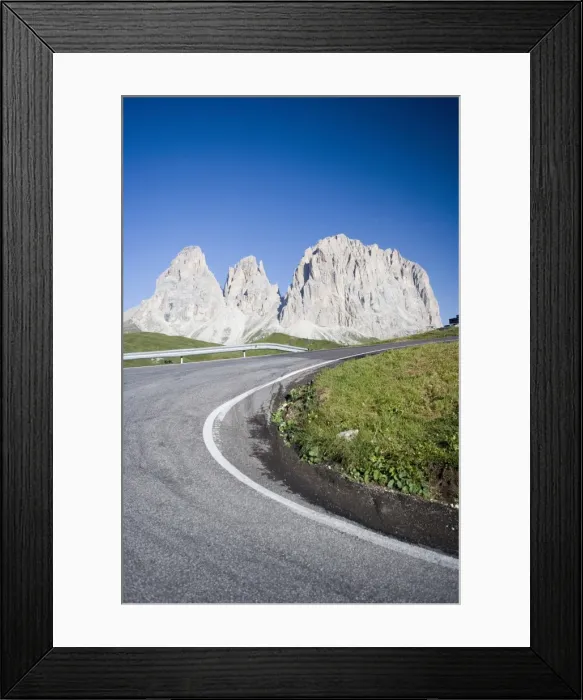 Framed Print : A bend in a road passing the craggy peaks of the Sassolungo in the Dolomites Framed Print : A bend in a road passing the craggy peaks of the Sassolungo in the Dolomites