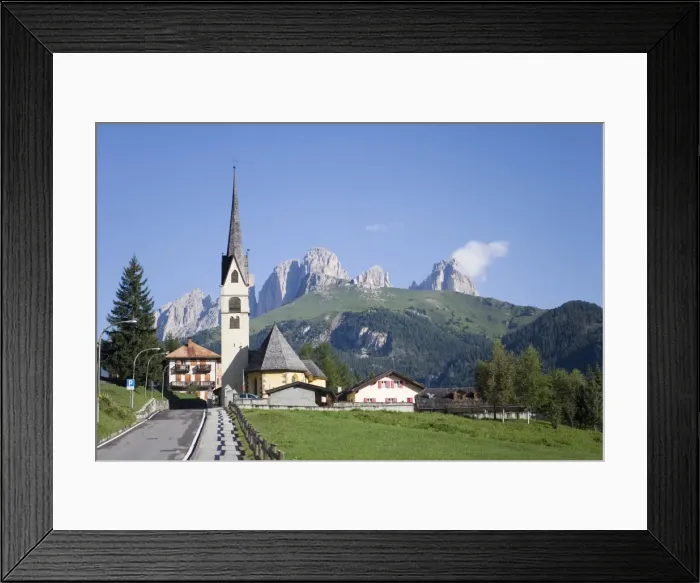 Framed Print : A church in the village of Alba with the rugged peaks of the Sassolungo in the distance Framed Print : A church in the village of Alba with the rugged peaks of the Sassolungo in the distance