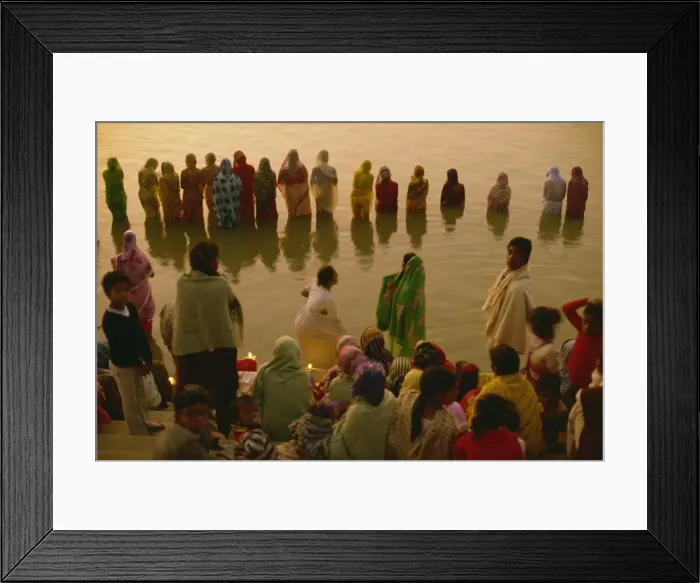 Framed Print : Hundreds of women gather in rows along river front, defying the cold, to welcome the rising sun god Framed Print : Hundreds of women gather in rows along river front, defying the cold, to welcome the rising sun god