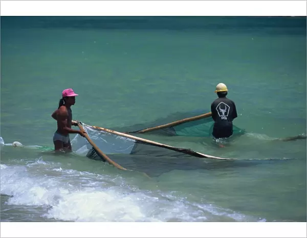 Men net fishing at Candidasa, Bali, Indonesia, Southeast Asia, Asia