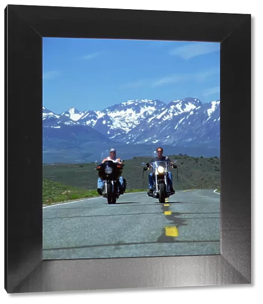 Harley Davidson bikers with snow-capped mountains in background, United States of America