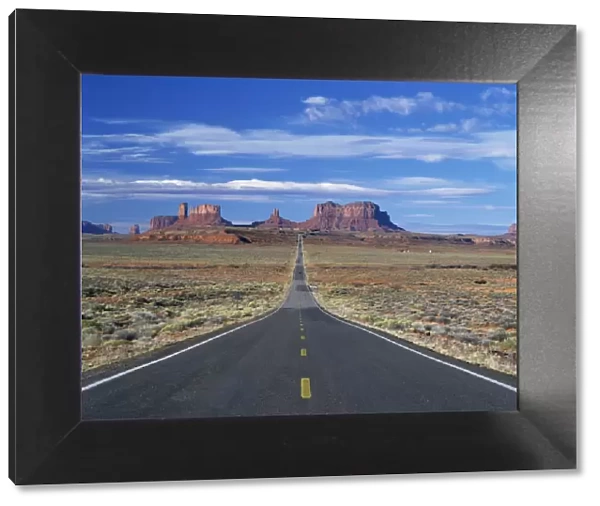 Straight road heading for Monument Valley, Navajo Reserve, on border of Arizona and Utah