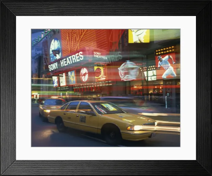 Framed Print : Yellow cabs on the street at night with neon lights of Sony Theatres in the background Framed Print : Yellow cabs on the street at night with neon lights of Sony Theatres in the background
