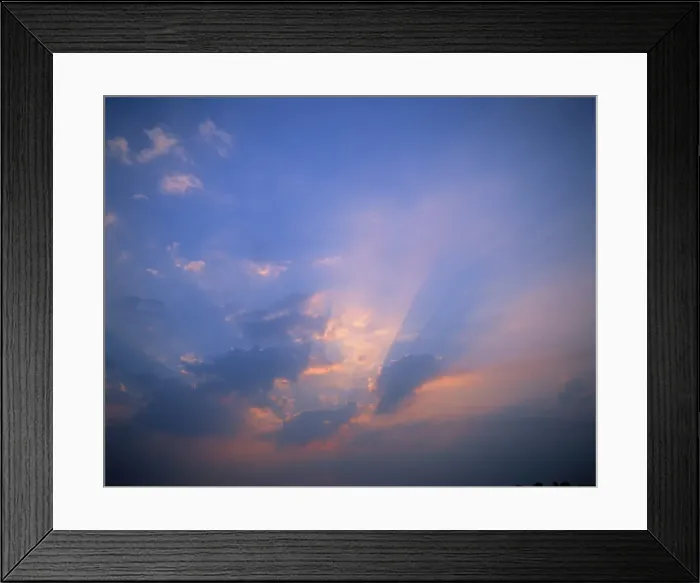 Framed Print : Rays of light bursting through clouds in a blue sky Framed Print : Rays of light bursting through clouds in a blue sky