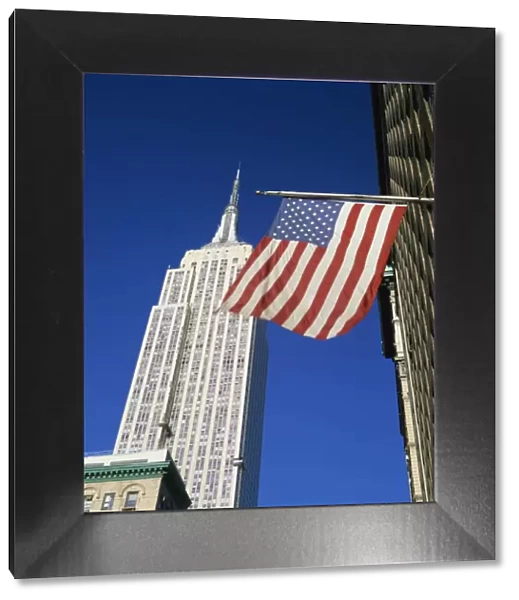 The American flag, the stars and stripes in front of the Empire State Building in New York