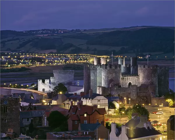 Floodlit Conwy Castle, UNESCO World Heritage Site, overlooking the town with the River Conwy estuary beyond at dusk, Gwynedd, North Wales, United