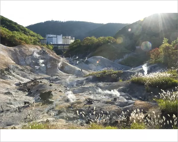 Steam vents in Jigokudani geothermal area, hotels of Noboribetsu Onsen beyond