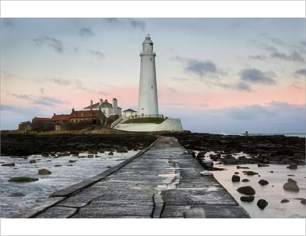 View along the tidal causeway to St. Marys Island and St. Marys Lighthouse at dusk