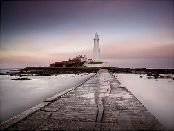 View along the tidal causeway to St. Marys Island and St. Marys Lighthouse at dusk