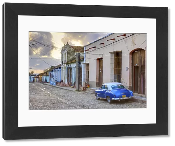 Cobbled street at sunset with classic American car, Trinidad, Cuba, West Indies