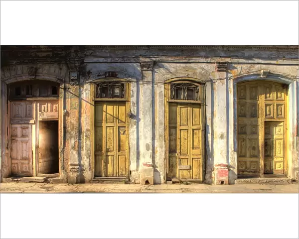 Facades of dilapidated colonial buildings bathed in evening light, Havana
