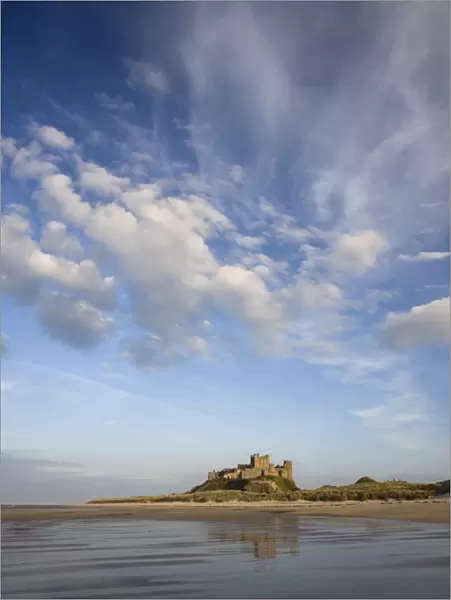 Bamburgh Castle bathed in evening light, viewed from Bamburgh Beach, Bamburgh