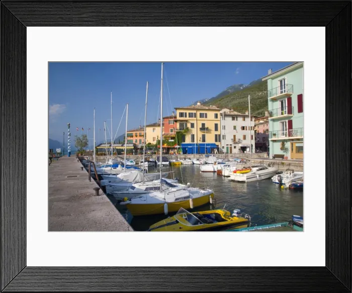Framed Print : View across the harbour to colourful houses on the shore of Lake Garda Framed Print : View across the harbour to colourful houses on the shore of Lake Garda