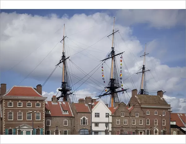 Masts and rigging of HMS Trincomalee, British Frigate of 1817, seen above old buildings at Hartlepools Maritime Experience, Hartlepool, Cleveland, England, United