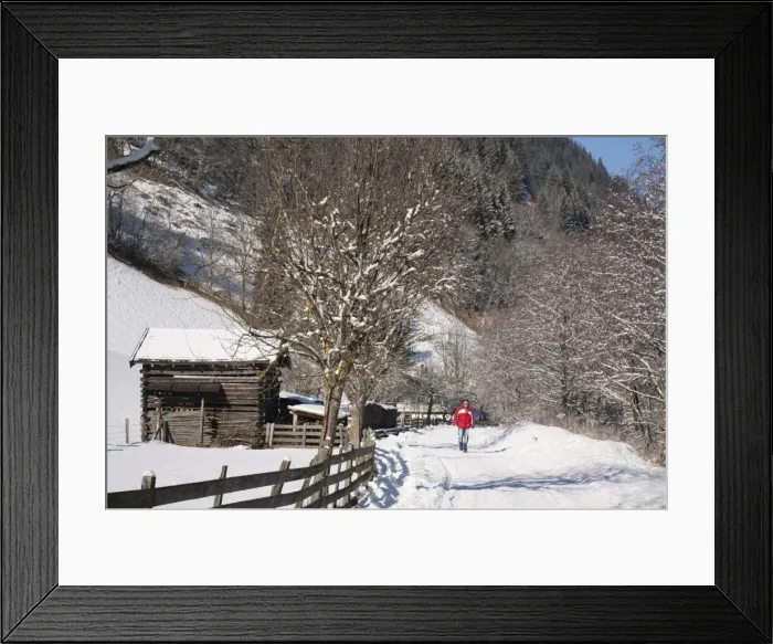 Framed Print : Man walking on Winterwanderweg cleared trail along Alpine valley with snow in winter Framed Print : Man walking on Winterwanderweg cleared trail along Alpine valley with snow in winter
