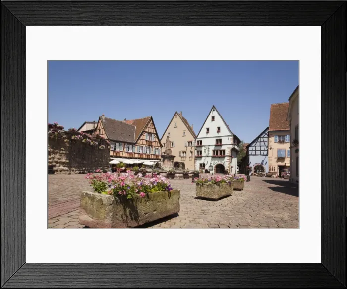 Framed Print : Flower tubs in Place du Chateau square in medieval village on the wine route