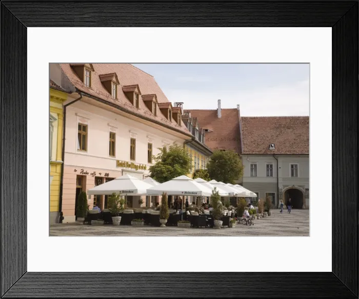 Framed Print : Old buildings and street cafe in historic city centre of Hermannstadt, Piata Mare Framed Print : Old buildings and street cafe in historic city centre of Hermannstadt, Piata Mare