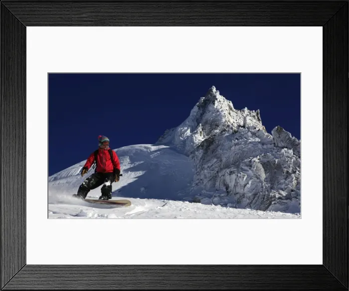 Framed Print : A snowboarder riding powder snow off the top of the famous Grand Montets ski area Framed Print : A snowboarder riding powder snow off the top of the famous Grand Montets ski area